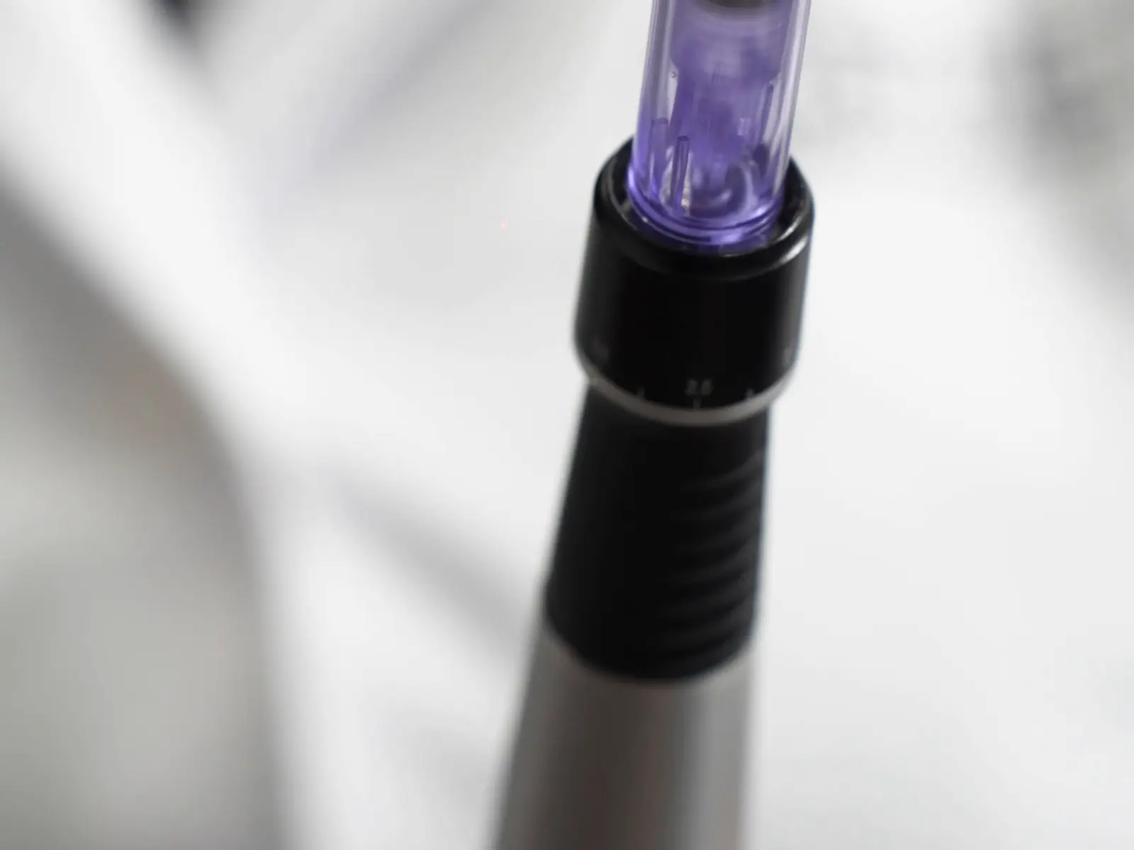 Dermapen en la mano de la instructora, detalle