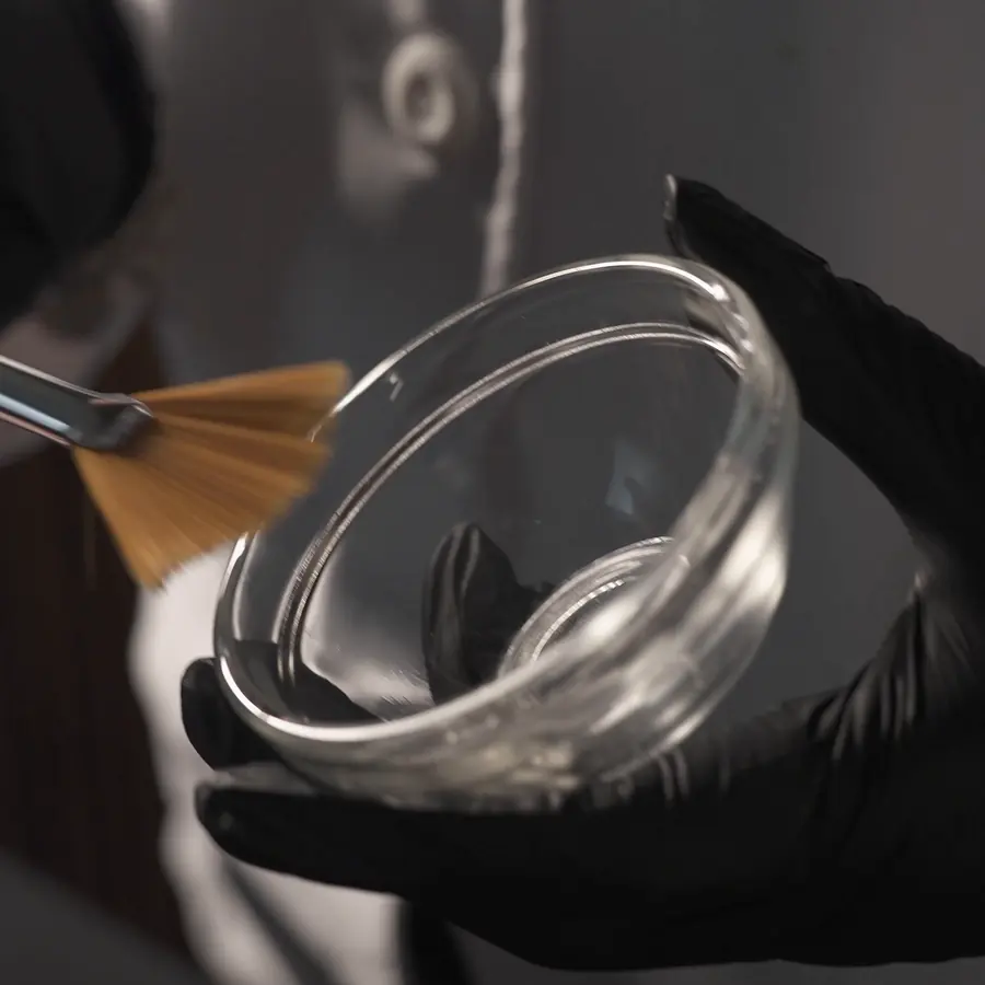 Bowl y pincel en manos con guantes negros, en clase de peeling